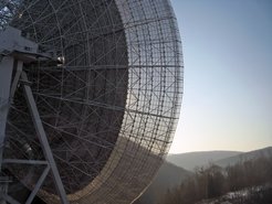 Ohr ins All: Das 100-Meter-Radioteleskop Effelsberg bei Beobachtungen im Rahmen eines regelmäßigen Suchprogramms für neue Pulsare in Richtung des galaktischen Zentrums. Dieses befindet sich in Richtung des Sternbilds Schütze (Sagittarius). Von Effelsberg aus steht es sehr tief am Horizont in südlicher Richtung und zeigt sich täglich nur für etwas mehr als zwei Stunden.