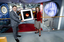 Prof. Dr. Anton Zensus übergibt der Leiterin des Deutschen Museums Bonns, Dr. Andrea Niehaus, das erste Bild eines Schwarzen Loches
