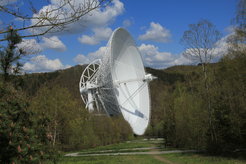 Abb. 1: Das 100-m-Radioteleskop nahe Bad Münstereifel-Effelsberg, ca. 40 km südwestlich von Bonn. Das Foto zeigt das Teleskop vom Besucherpavillon aus. Ein kurzer Zickzackweg führt von dort aus zu einem Aussichtsplateau unmittelbar vor dem Teleskop selbst.