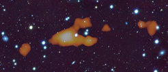 Das Bild zeigt eine riesige Wasserstoffwolke im intergalaktischen Raum, beobachtet mit dem MeerKAT Radioteleskop. Die Wolke gibt Forschern Rätsel auf, da sie so massiv ist wie eine Galaxie, aber vielleicht gar keine Sterne enthält.