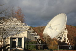 Abb. 1: Der Besucherpavillon am Radioteleskop Effelsberg. Dort befindet sich der Zielpunkt des Planetenwegs (Station „Sonne“). Über einen kurzen Zickzackweg ist der Zielpunkt des Milchstraßenwegs (Station „Zentrum der Milchstraße“) unmittelbar vor dem 100-m-Radioteleskop erreichbar.