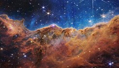 Abb. 1: Eine der ersten Aufnahmen mit dem James-Webb-Teleskop („First Light“ vom Juli 2022). Sie zeigt ein Detailbild des Carinanebels (NGC 3324), eines Sternentstehungsgebiets in der Milchstraße in Richtung des Sternbilds Carina am Südhimmel. Diese Himmelsregion ist von Europa aus nicht sichtbar.